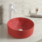 赤い洗面器をはねかける滑らかなカウンター トップの浴室の流しの干潮