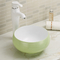 なめらかで、優雅なカウンター トップの浴室の流しの白い楕円形の形の洗面器